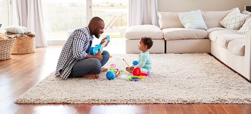 father and child playing on living room floor